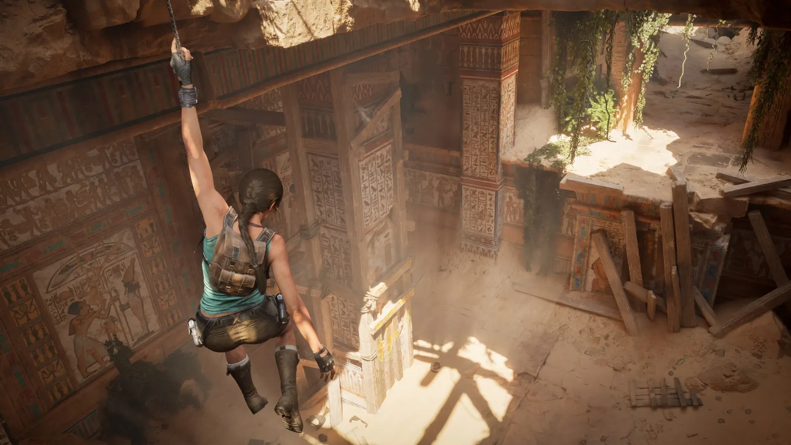 Lara climbing through sunlit stone ruins in an official screenshot